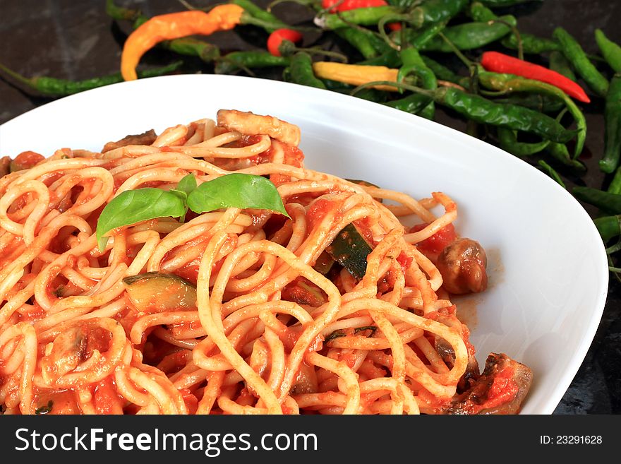 Image of a plate of spaghetti with tomato sauce and chilli peppers. Image of a plate of spaghetti with tomato sauce and chilli peppers