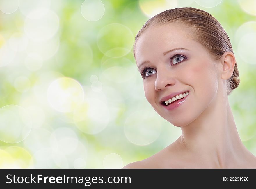 Beautiful face of a healthy young woman on a green background