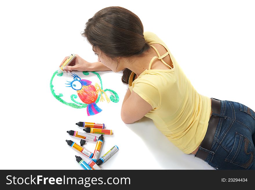 Portrait of cute young woman lying in the studio and draws with colored paint on fabric, isolated. Portrait of cute young woman lying in the studio and draws with colored paint on fabric, isolated