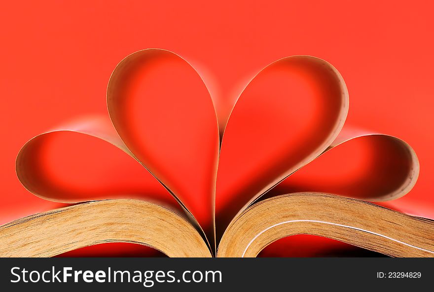Heart-shaped book on red background
