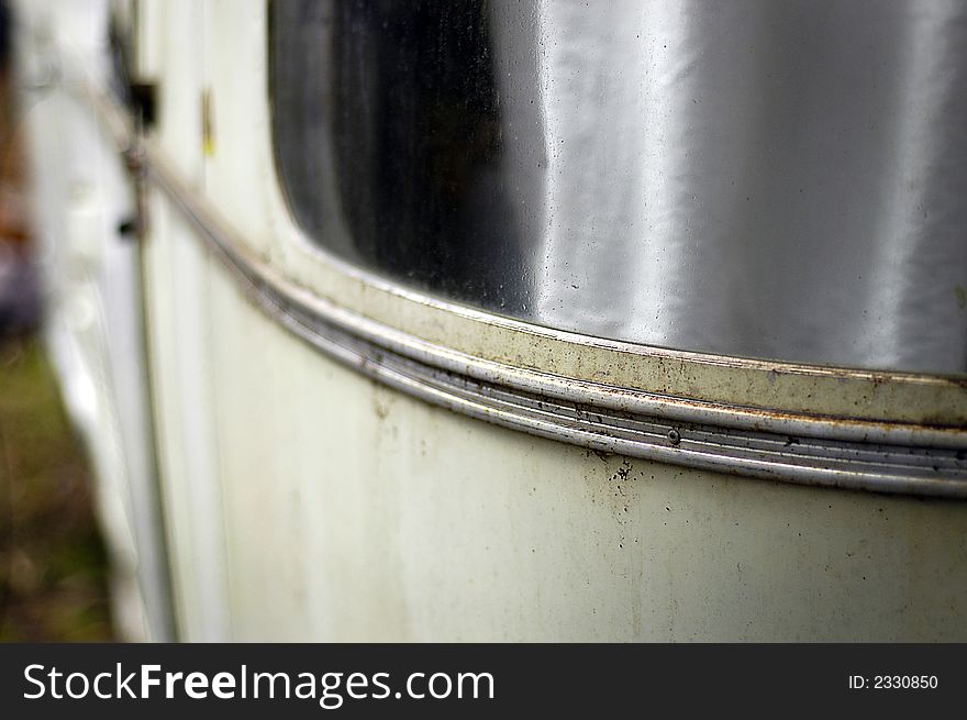 The curved window of a streamlined travel trailer of the late sixties showing deterioration, shallow DOF. The curved window of a streamlined travel trailer of the late sixties showing deterioration, shallow DOF.