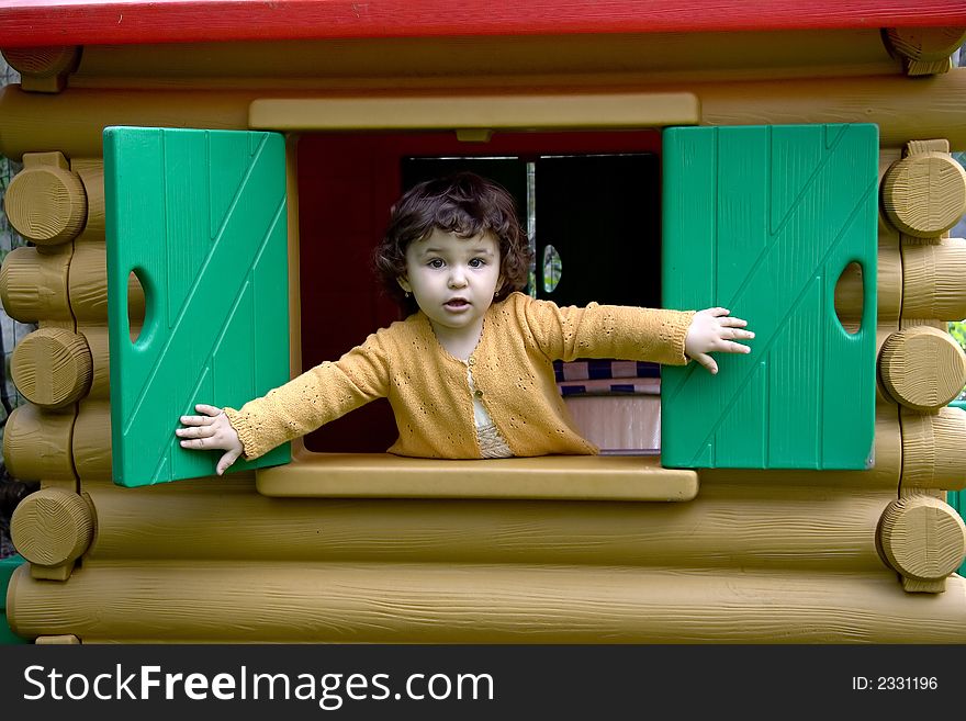 Little girl plays in dolls house