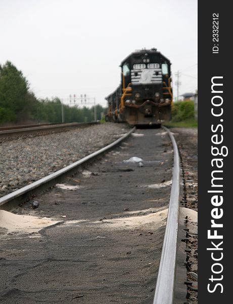 Close up of railroad tracks with locomotive in the background. Close up of railroad tracks with locomotive in the background