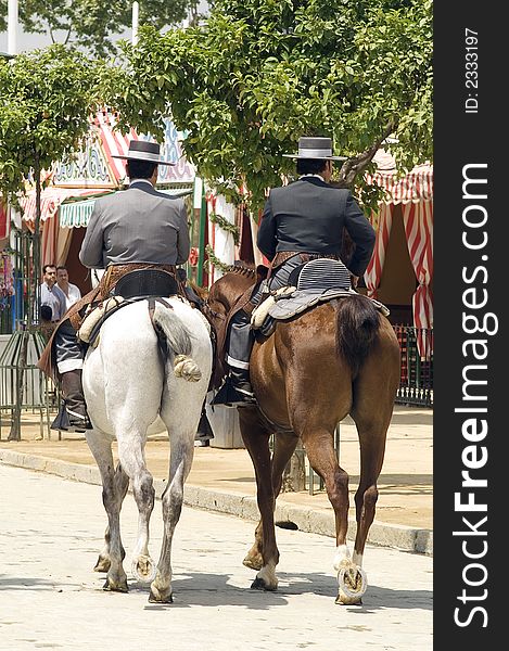 Riders taking a walk by the fair of Seville. Riders taking a walk by the fair of Seville