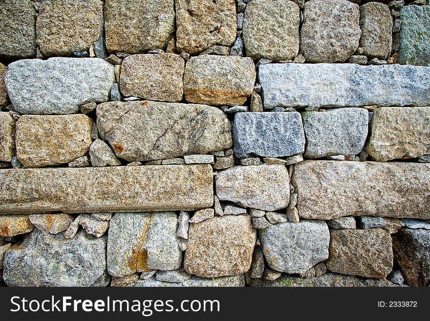 Colorful and textured stone masonry wall useful for backgrounds