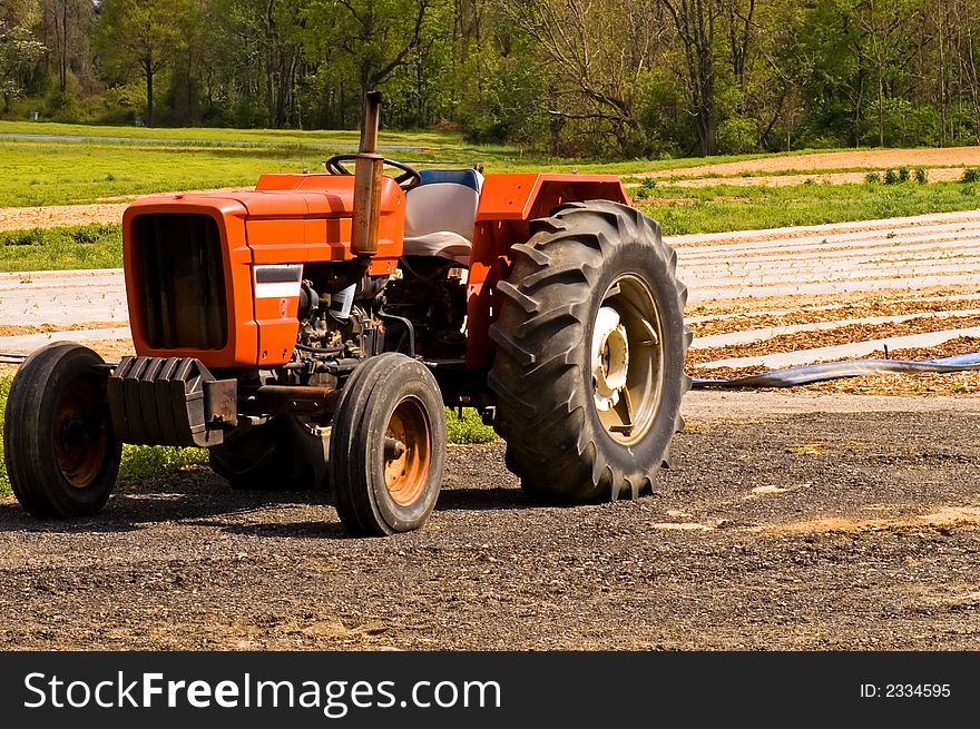 Red farm tractor in field