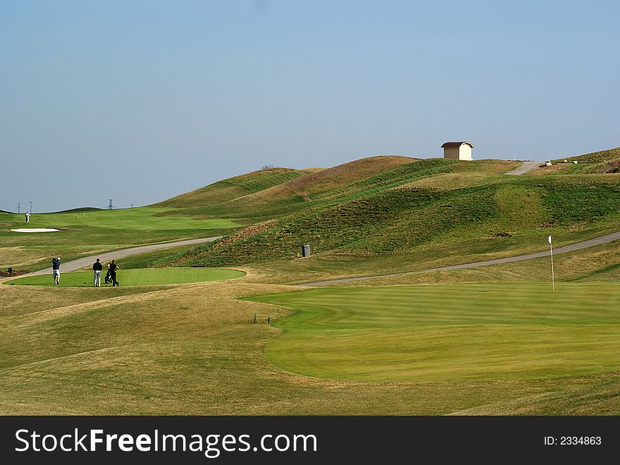 Photo of green golf course with landscape hill background. Photo of green golf course with landscape hill background