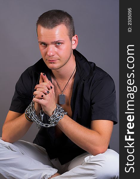 Portrait of young man with chain and painted nails