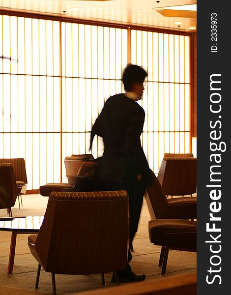 Man passing through lounge with japanese rice wall. Man passing through lounge with japanese rice wall