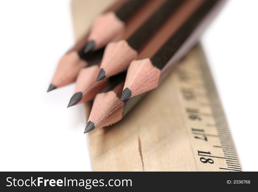 Sharp pencils and ruler on white background with narrow DOF