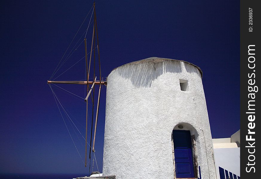 Whitewashed windmill in Santorini against a bright blue sky. Whitewashed windmill in Santorini against a bright blue sky