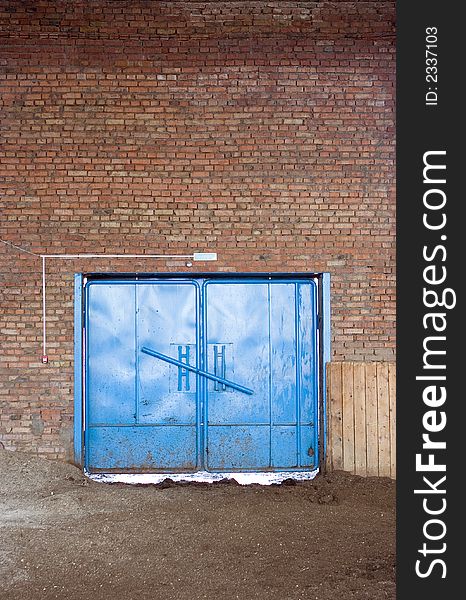 Blue gate in brick wall with desk