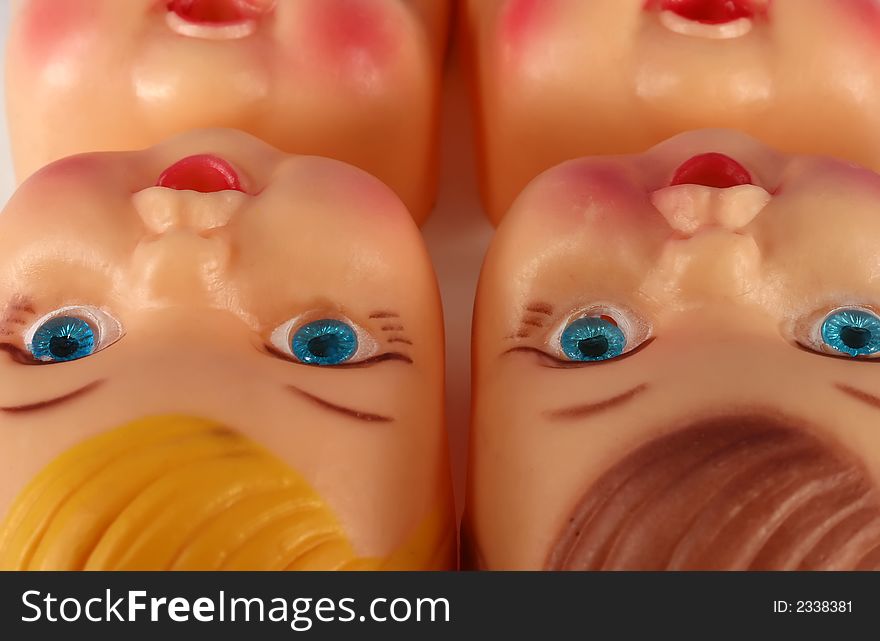 A close up of plastic doll faces on an assembly line. A close up of plastic doll faces on an assembly line