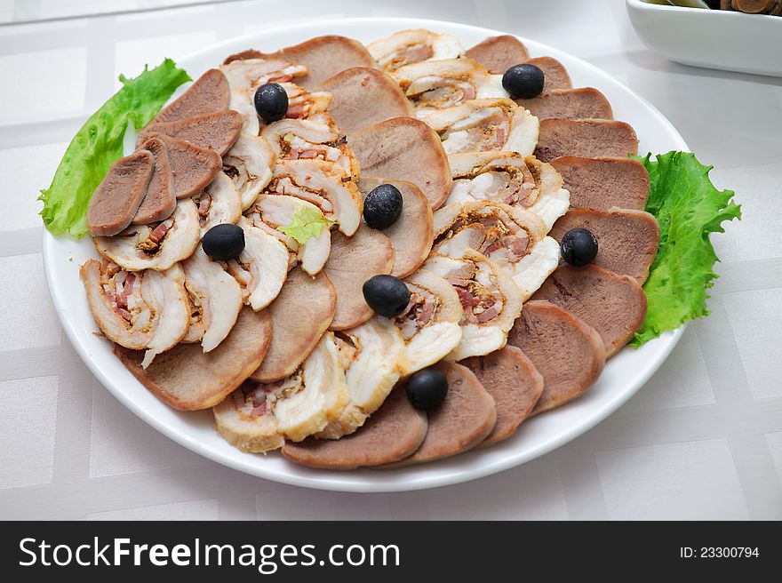 Appetizing meat slices is spread out to plate