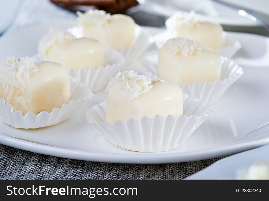 Chocolates in heart shaped white chocolate on the tablecloth. Chocolates in heart shaped white chocolate on the tablecloth