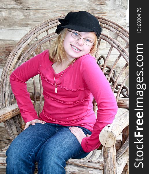 Image of a teenager sitting in a old wooden chair, posing and smiling. Image of a teenager sitting in a old wooden chair, posing and smiling