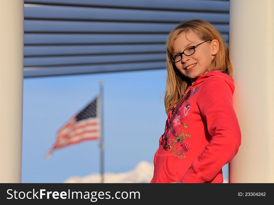 Portrait of a teenager leaning against a column with the nations flag in the background. Portrait of a teenager leaning against a column with the nations flag in the background