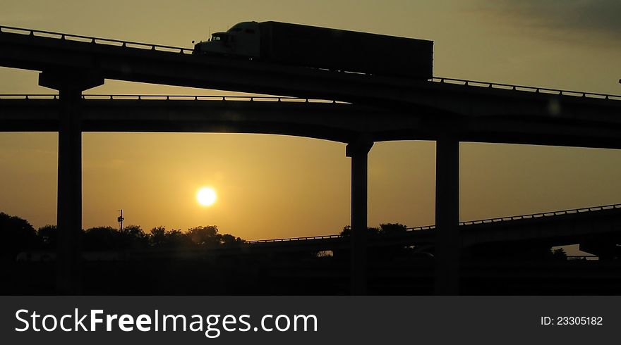 Truck goes over the bridge against the backdrop of the evening setting sun. Truck goes over the bridge against the backdrop of the evening setting sun
