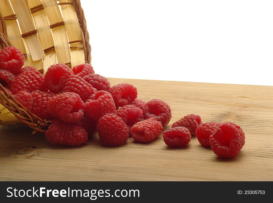 Raspberries with basket on wooden table. Raspberries with basket on wooden table