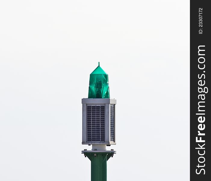 Green lighthouse in a port