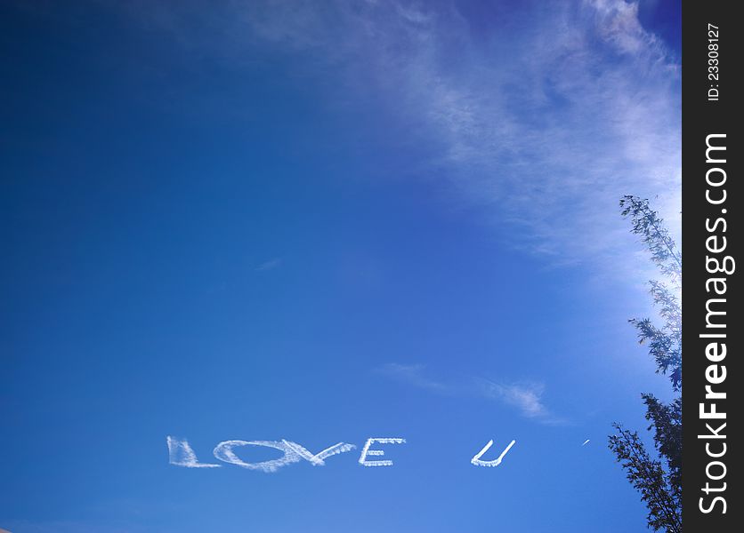 White LOVE U text created with airplane jet at blue sky. White LOVE U text created with airplane jet at blue sky