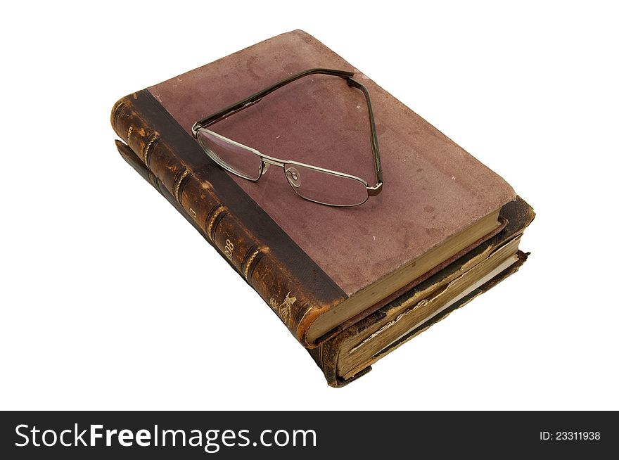 An old book and reading glasses on white background. An old book and reading glasses on white background