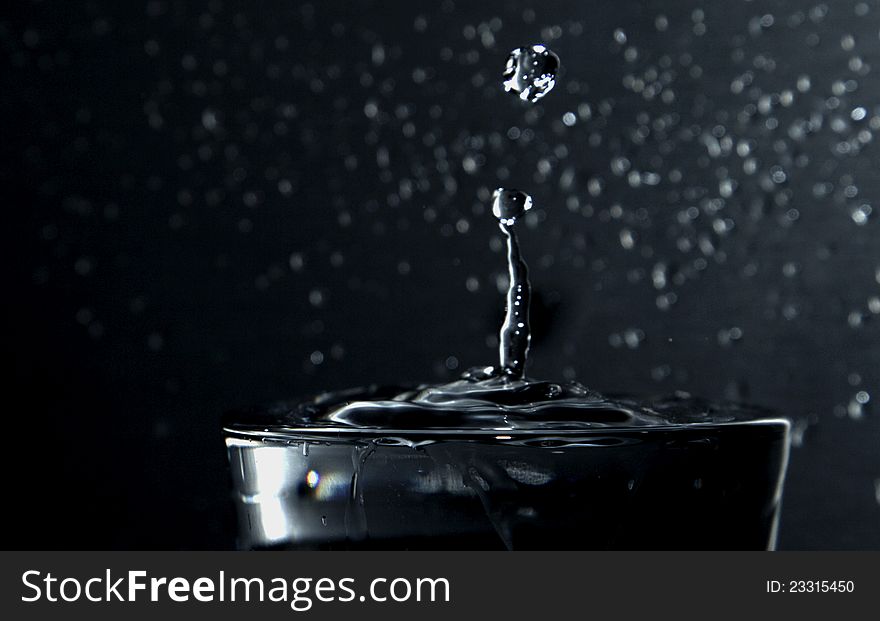 Falling waterdrop in a glass of water. Falling waterdrop in a glass of water