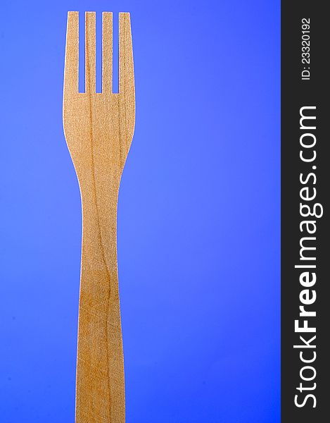 Wooden Fork On Blue Background With Copy Space