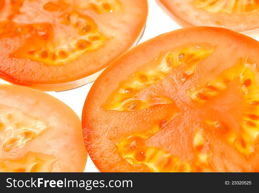 Backlit fresh tomato slices close-up. Backlit fresh tomato slices close-up