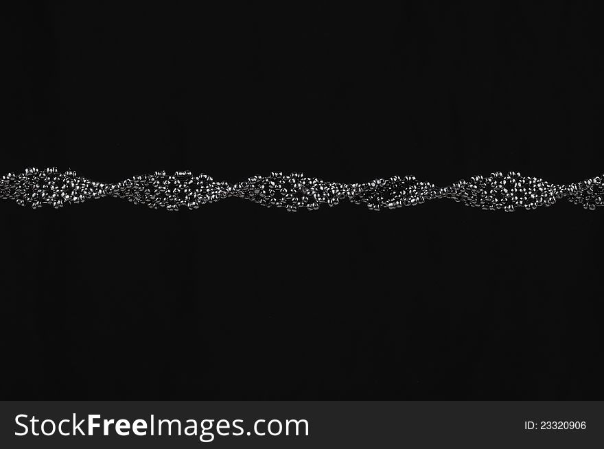 A handmade woven seed bead necklace on a black background