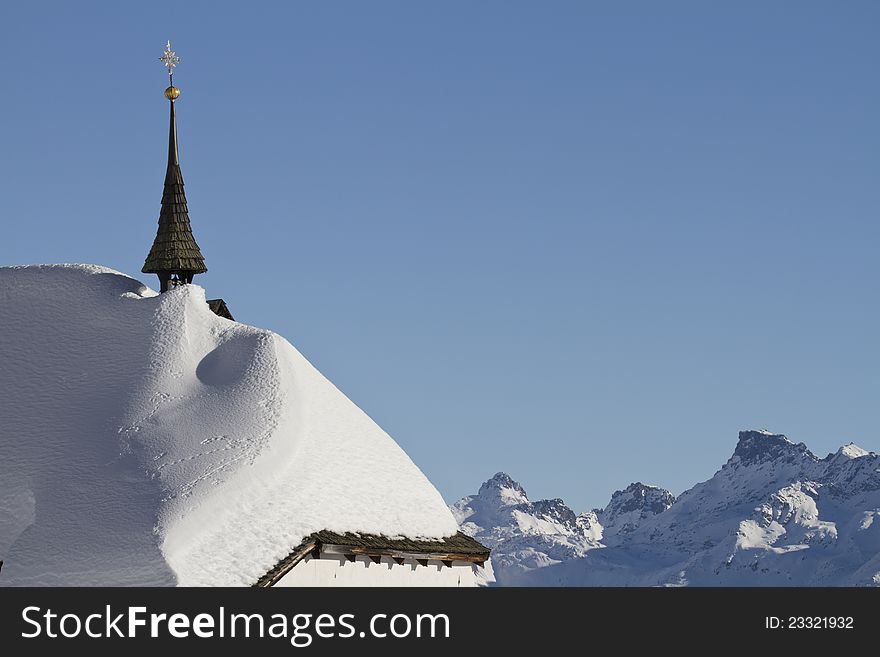 Snowbound historic church with mountains in background