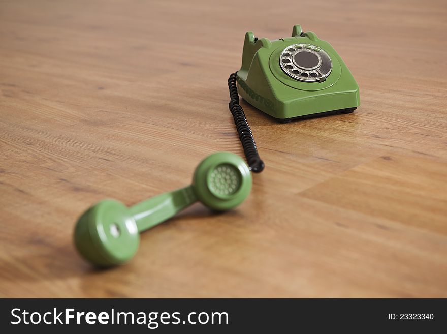 Vintage green phone over a wood floor