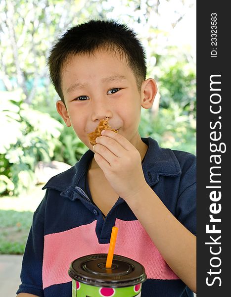 Asian boy eating muffin