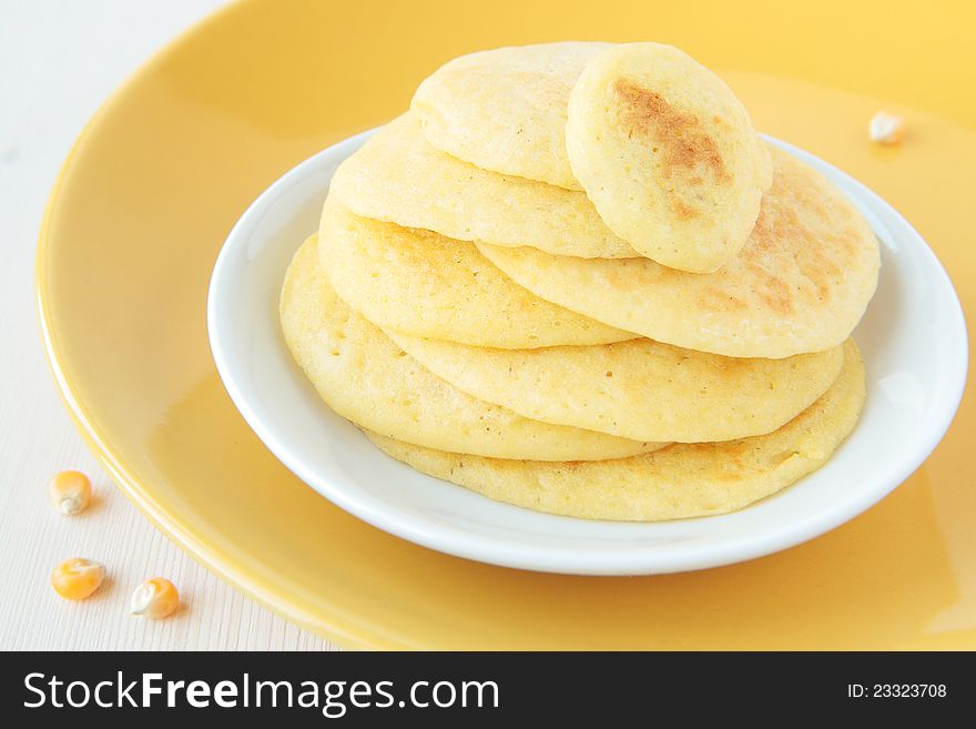 A stack of pancakes made ​​of maize flour on a yellow plate