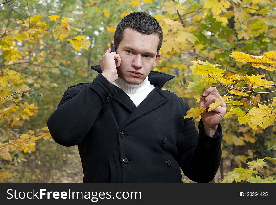 Portrait of young man with cell-phone ,ambient light and silver reflection