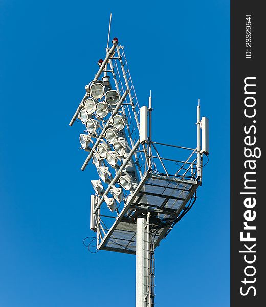 Stadium floodlight tower over blue sky