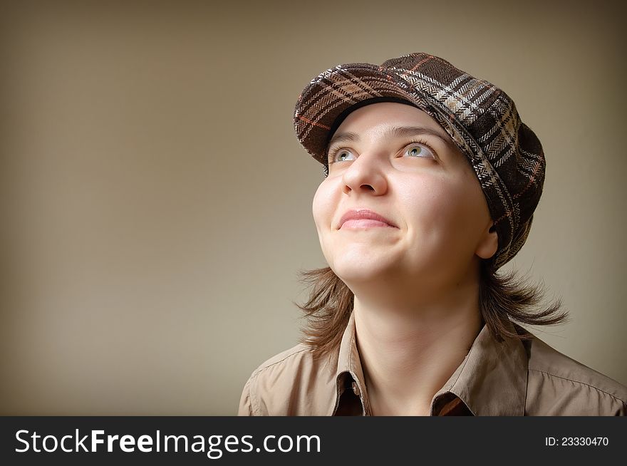 Portrait of a young woman smiling in checked cap. Portrait of a young woman smiling in checked cap