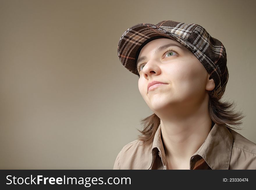 Young green eyed woman daydreaming in checked cap. Young green eyed woman daydreaming in checked cap