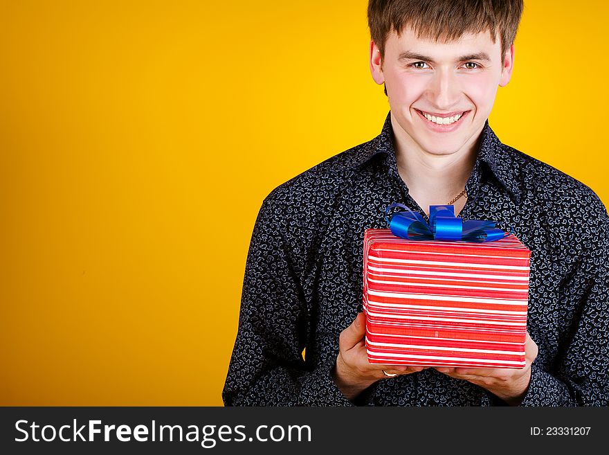 Present gift holding man looking smiling. Present gift holding man looking smiling