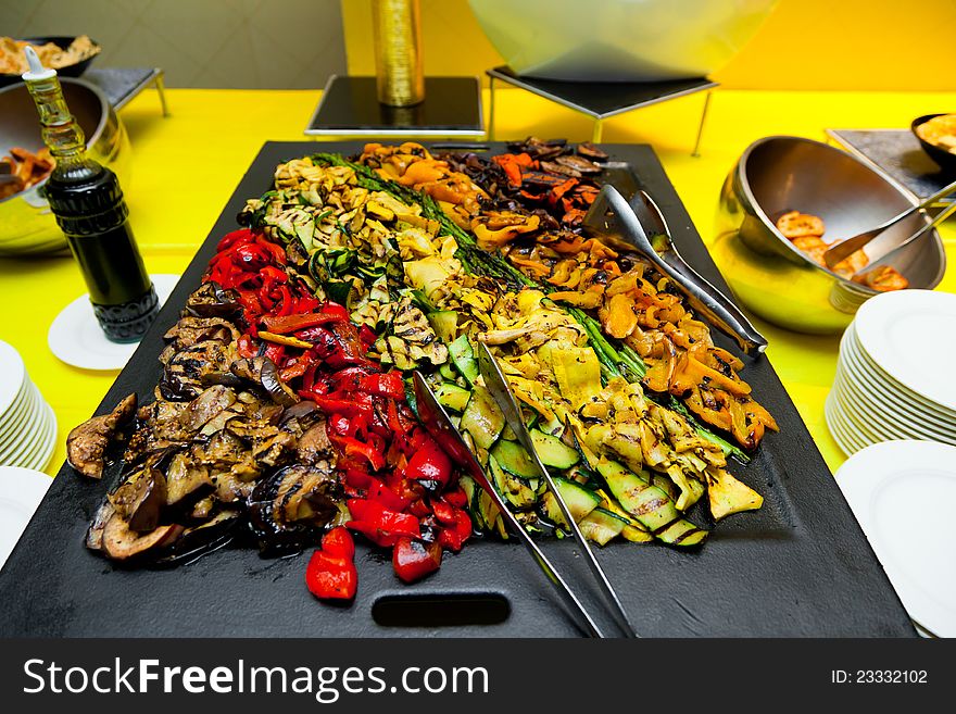 A tray filled with roasted peppers, squash, eggplant and asparagus at a catered event. A tray filled with roasted peppers, squash, eggplant and asparagus at a catered event.