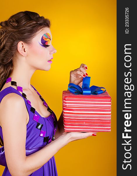 Young beautiful woman with make up is opening gift