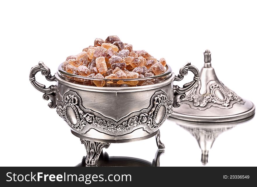 Brown sugar in, metal sugar bowl, isolated ,reflection