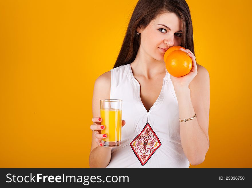 Pretty woman with juice an orange on yellow. Pretty woman with juice an orange on yellow