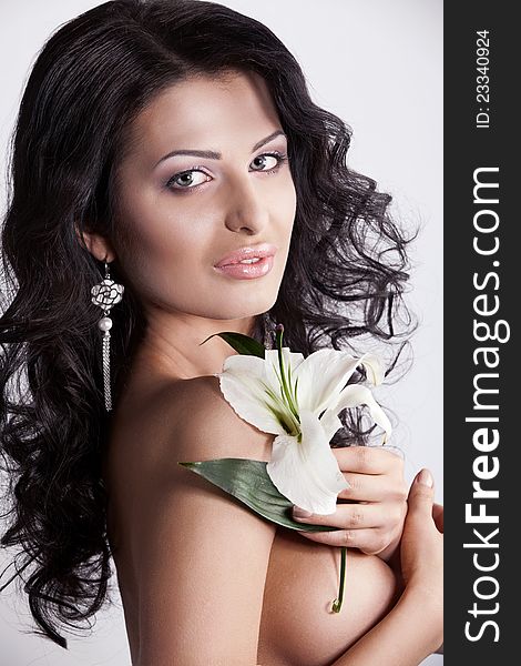 Beautiful young woman with lily flower. Close-up portrait