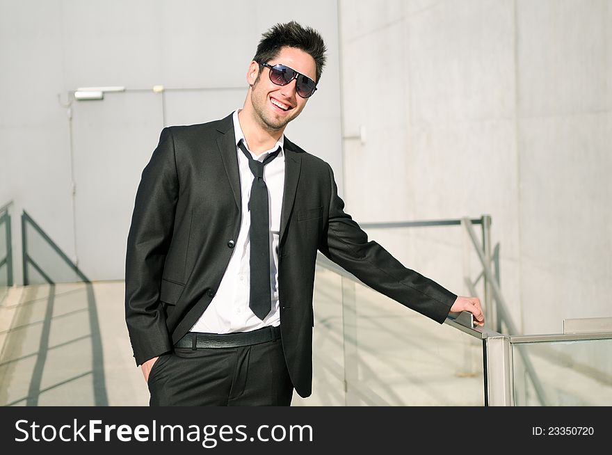 Portrait of a handsome young businessman smiling with sunglasses. Portrait of a handsome young businessman smiling with sunglasses