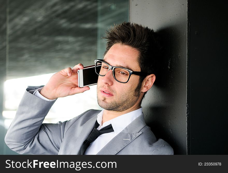 Portrait of a handsome young business man talking on mobile phone. Portrait of a handsome young business man talking on mobile phone