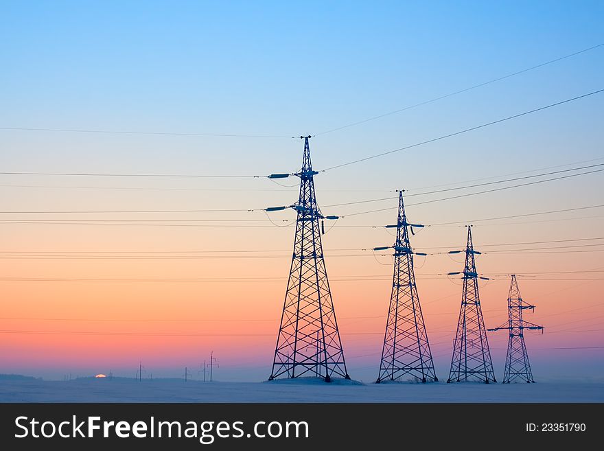 Electrical mast morning snow sunrise voltage cables. Electrical mast morning snow sunrise voltage cables
