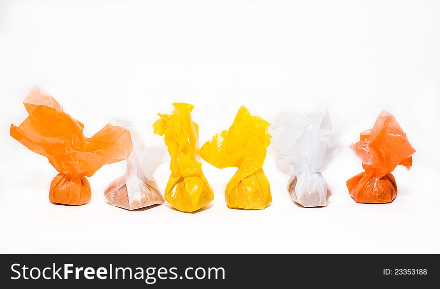 Toffees in many-coloured wrappers on white background