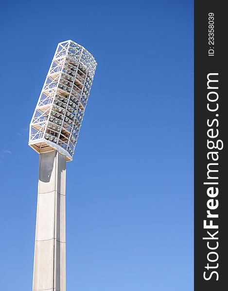 White floodlights found in sports arenas against blue sky background