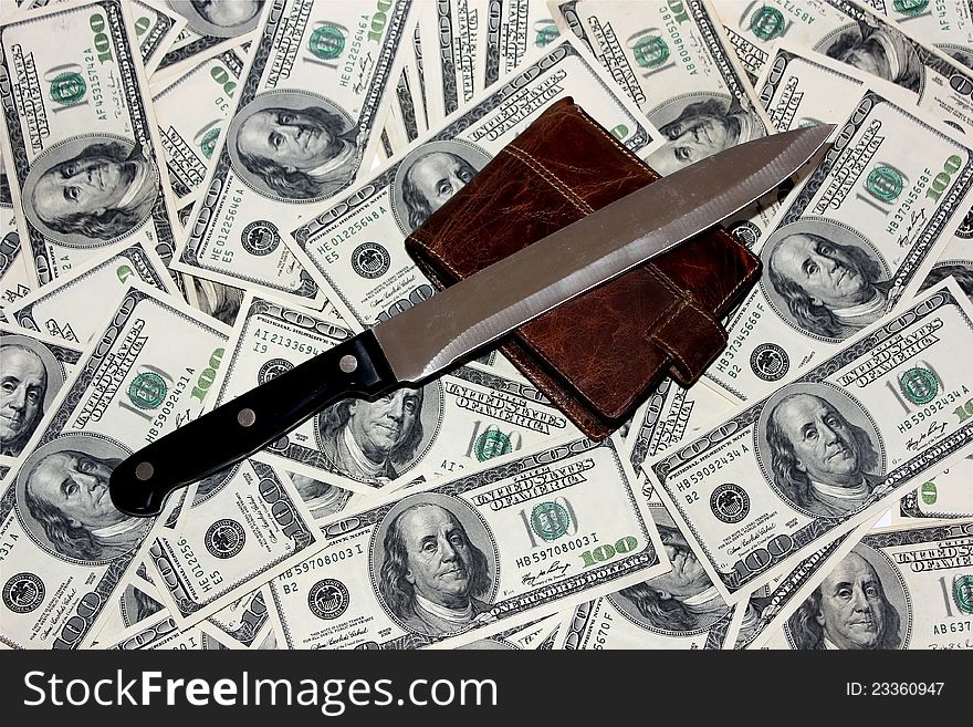 Knife and a purse lying on the 100 dollar bills. Knife and a purse lying on the 100 dollar bills